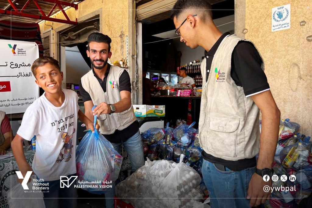 distribute food parcels to displaced families in the Al-Mawasi area of Khan Younis